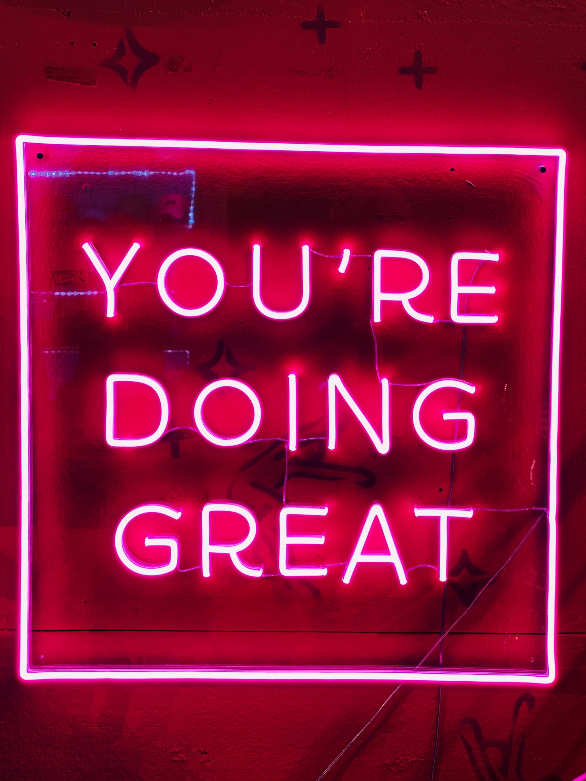 Pink neon light with the words: "you're doing great"
