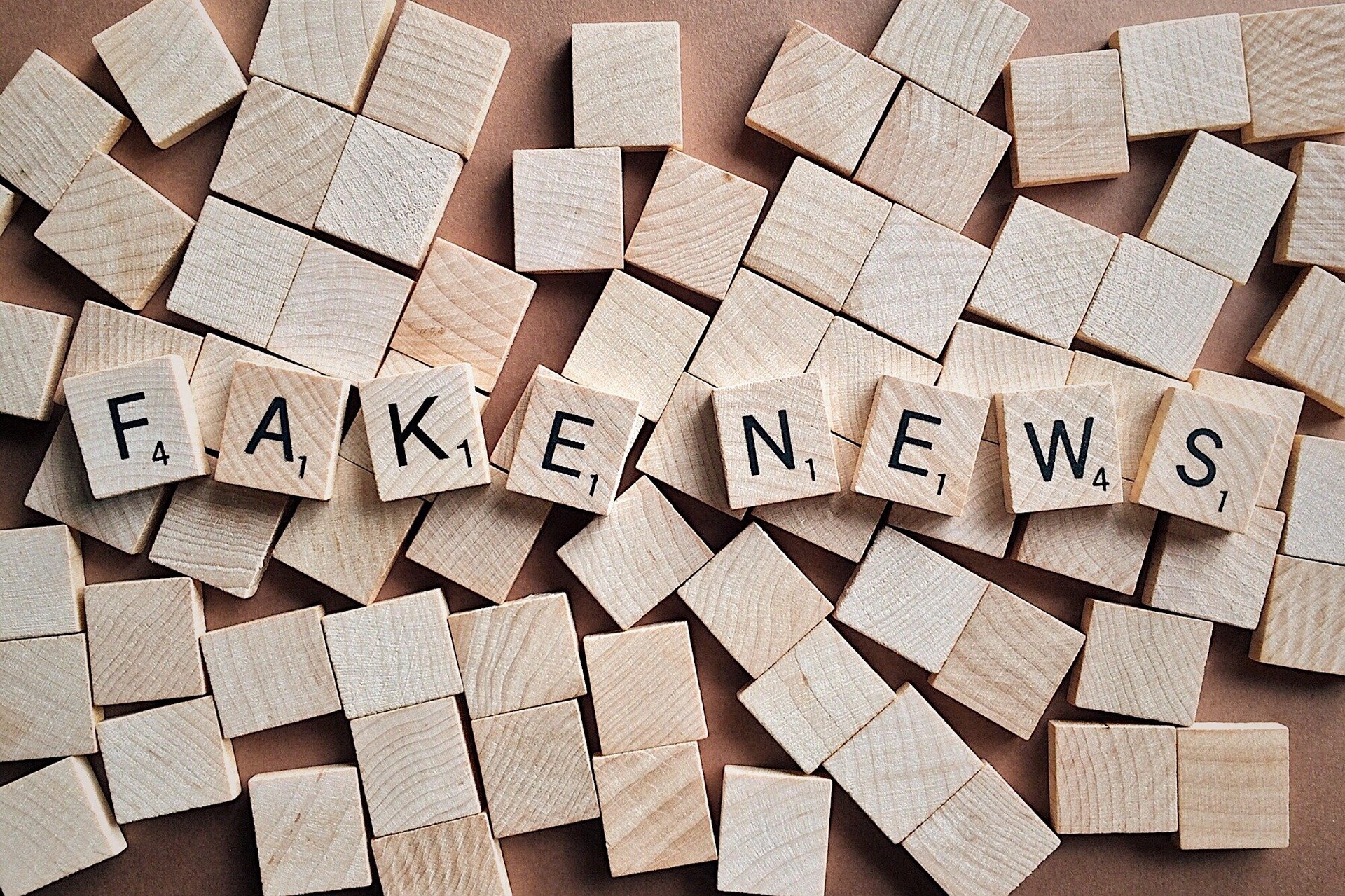 a set of scrabble tiles spelling "fake news"