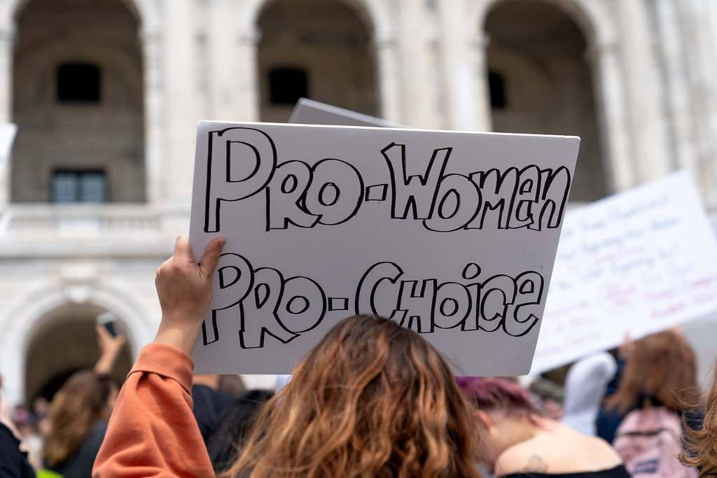 Person holding up a sign which says "Pro-women, pro-choice"
