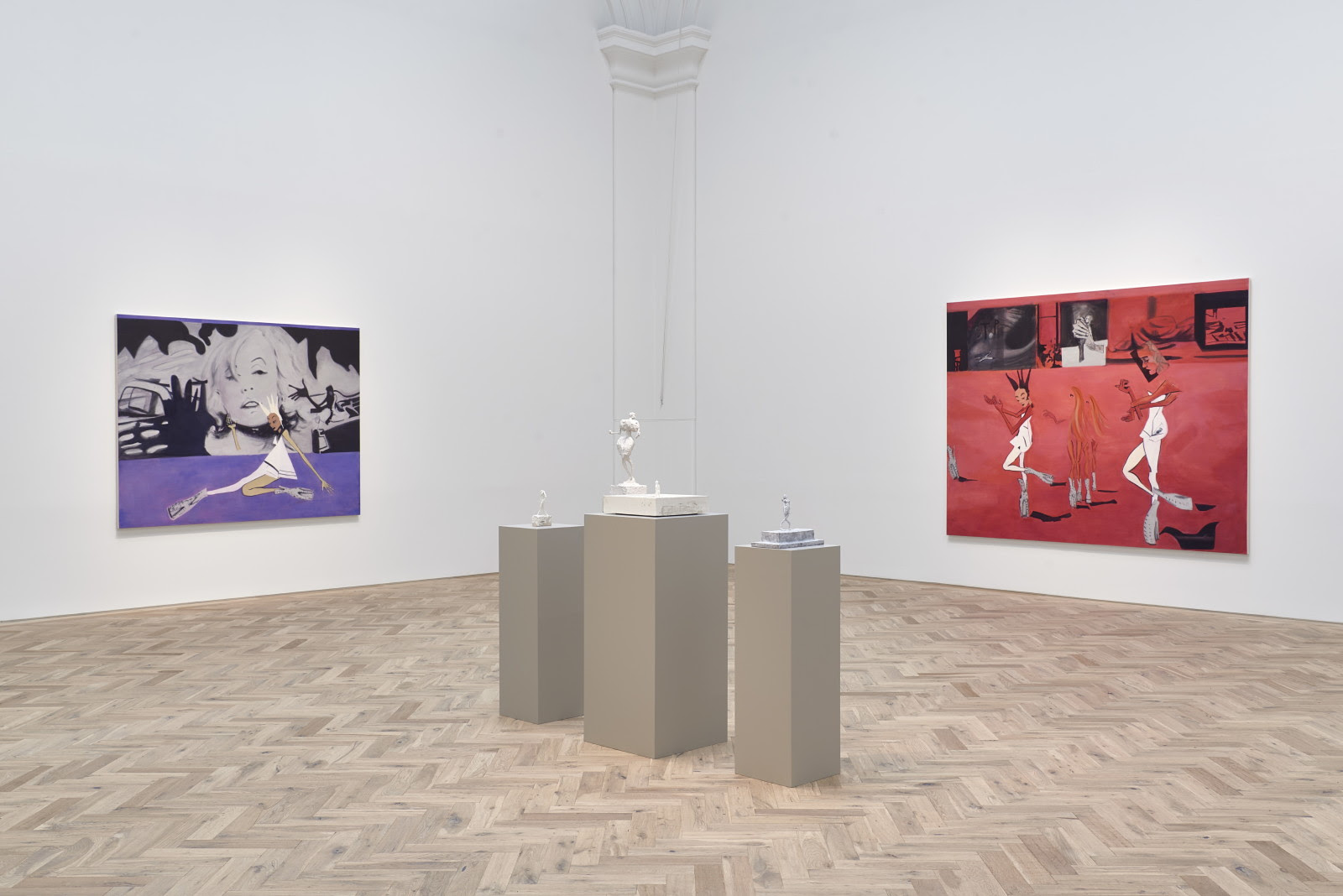 Gallery view with white wall and wooden floor. In the middle of the room on three brown plinth there are three white-ash sculptures. Hung at the walls are two big canvases