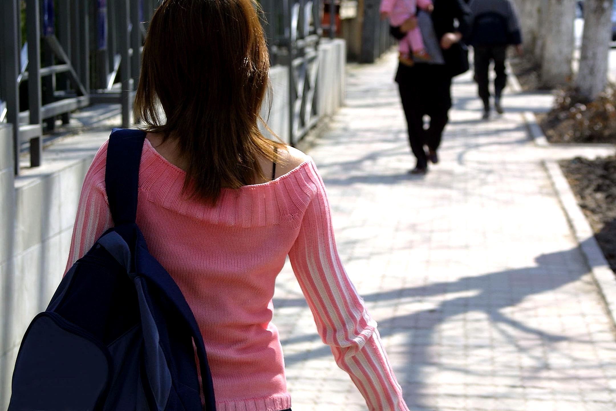 image shows a woman walking away from the camera
