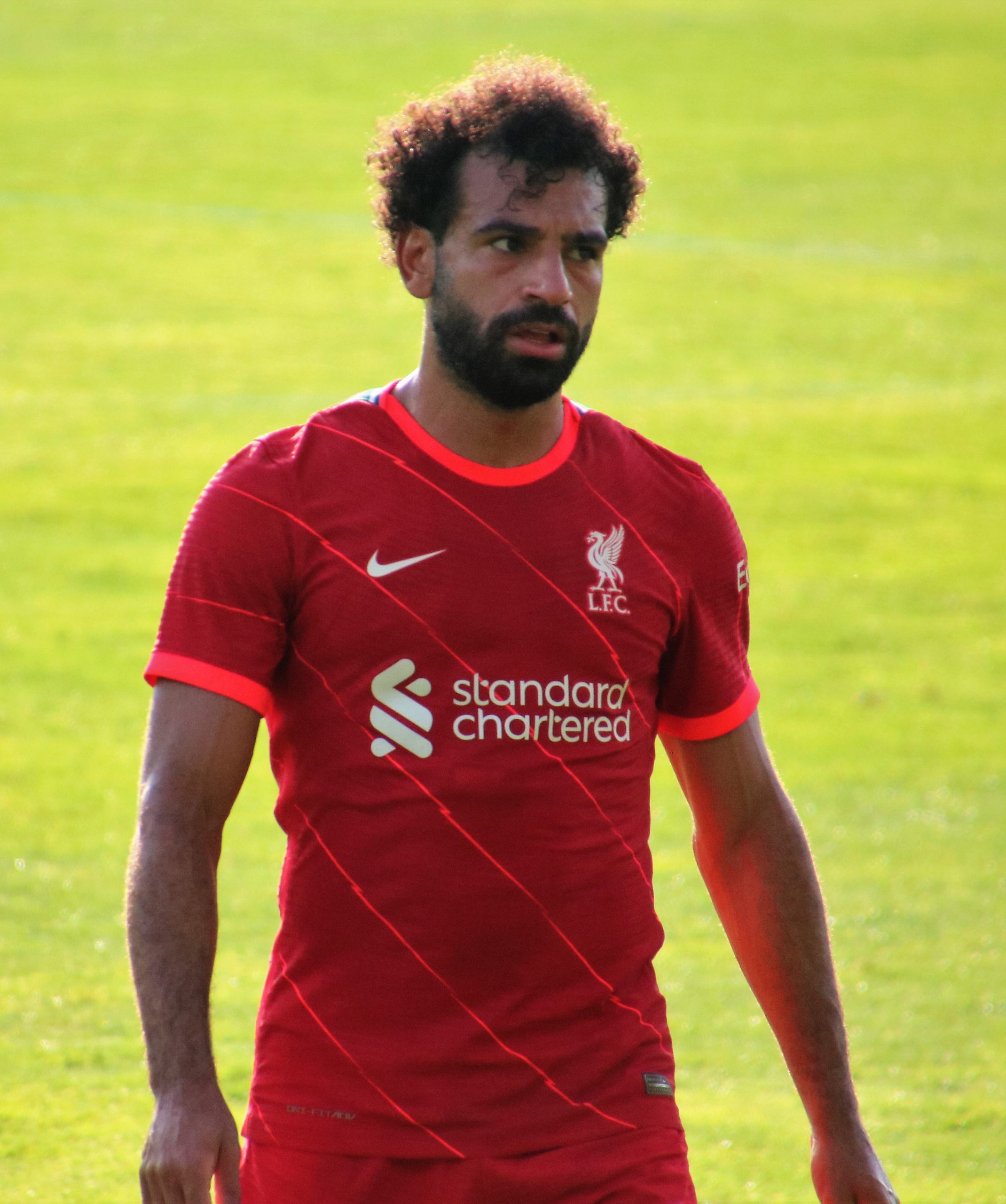 mo salah on a football pitch in a red jersey