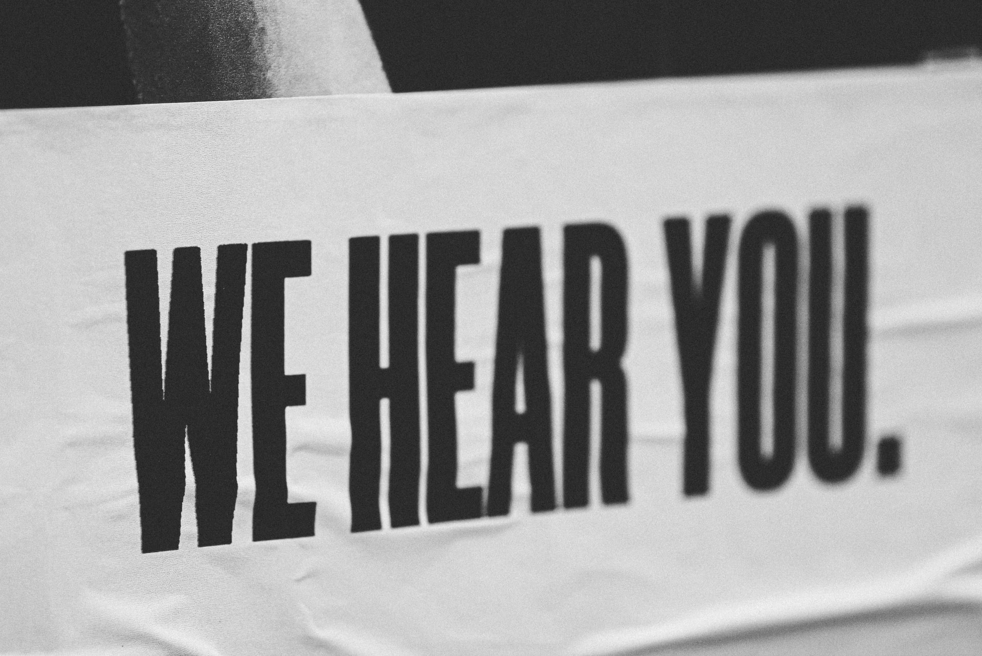 Poster reading 'We hear You' or bold, block caps