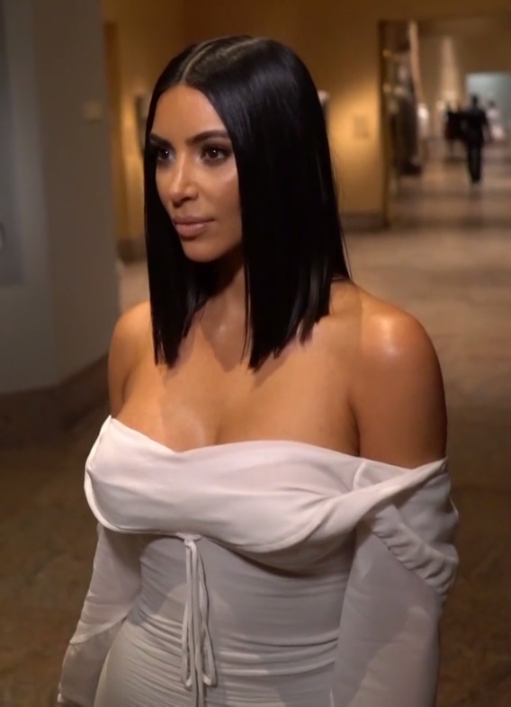 Kim Kardashian at the 2017 Met Gala. She is wearing an off-the-shoulder white dress and looking away from the camera.