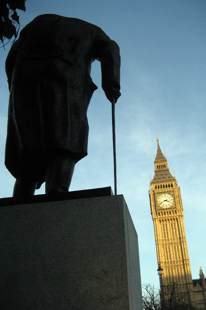 An image of the House of Parliament in the shadow of a statue of Winston Churchill