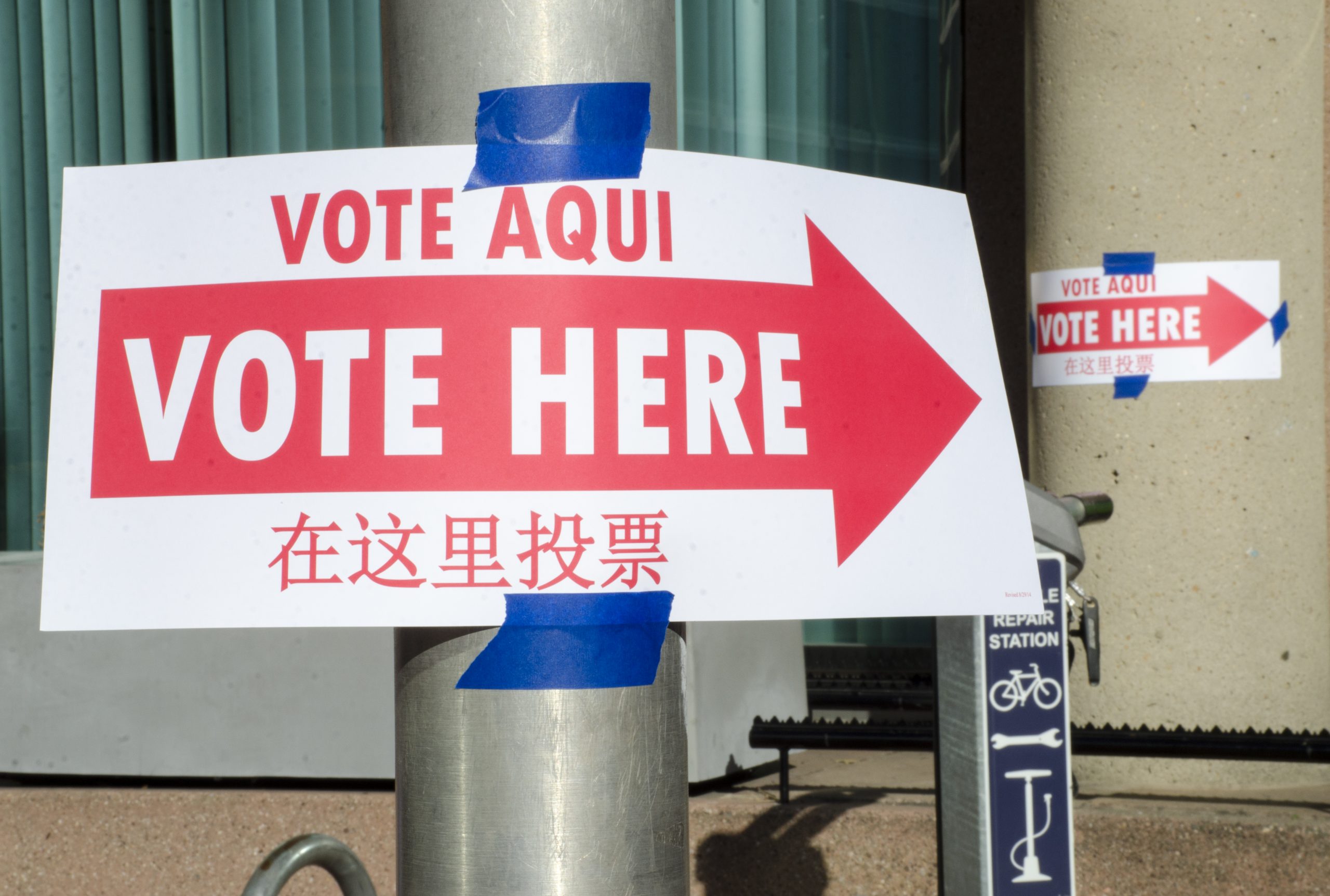 Voting signs in Spanish, English, and Chinese show the way to the polling station.