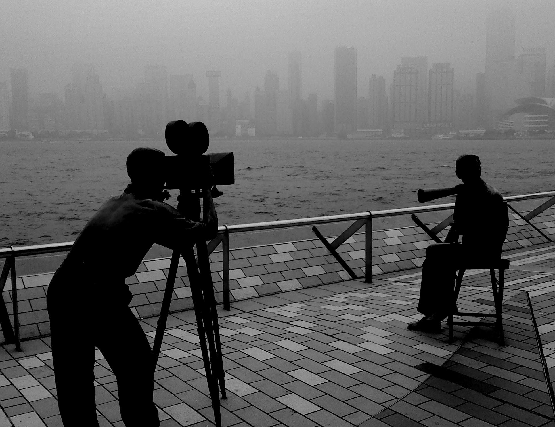 A person filming against the backdrop of a misty city