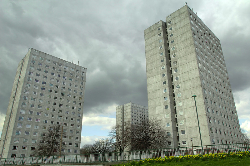 Concrete high rise social housing against a gray sky.