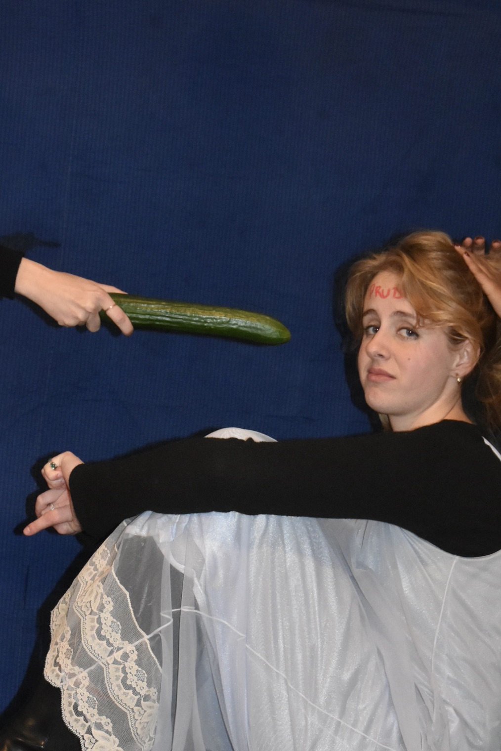 a displeased woman with a cucumber in front of her face