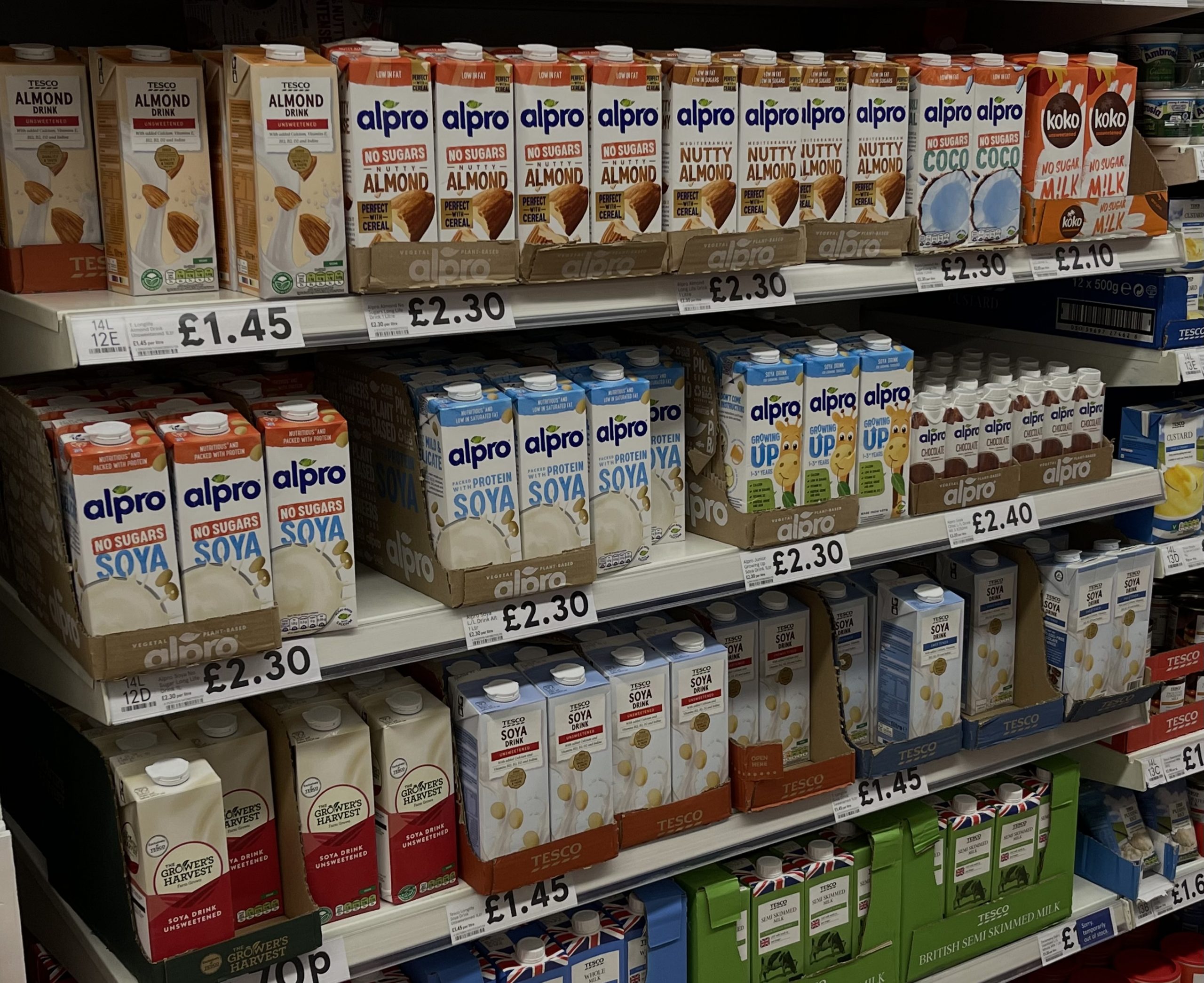 A wall of plant-based milks in a supermarket.